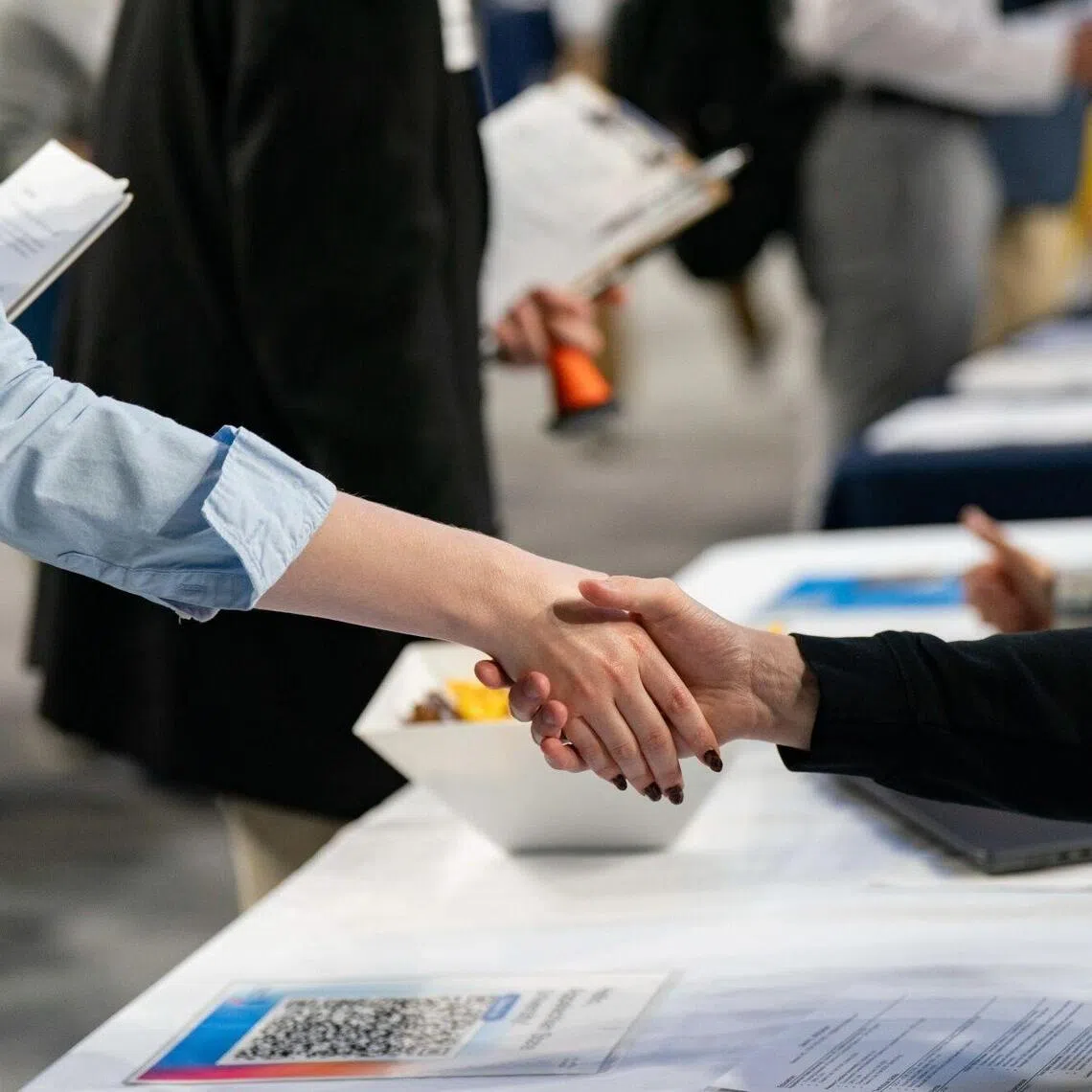 A recruiter and a job seeker shake hands at the Appalachian State University internship and job fair in Boone, North Carolina, US, on Wednesday, Oct. 1, 2025. The Department of Labor is expected to release initial jobless claims figures on October 2. Photographer: Allison Joyce/Bloomberg