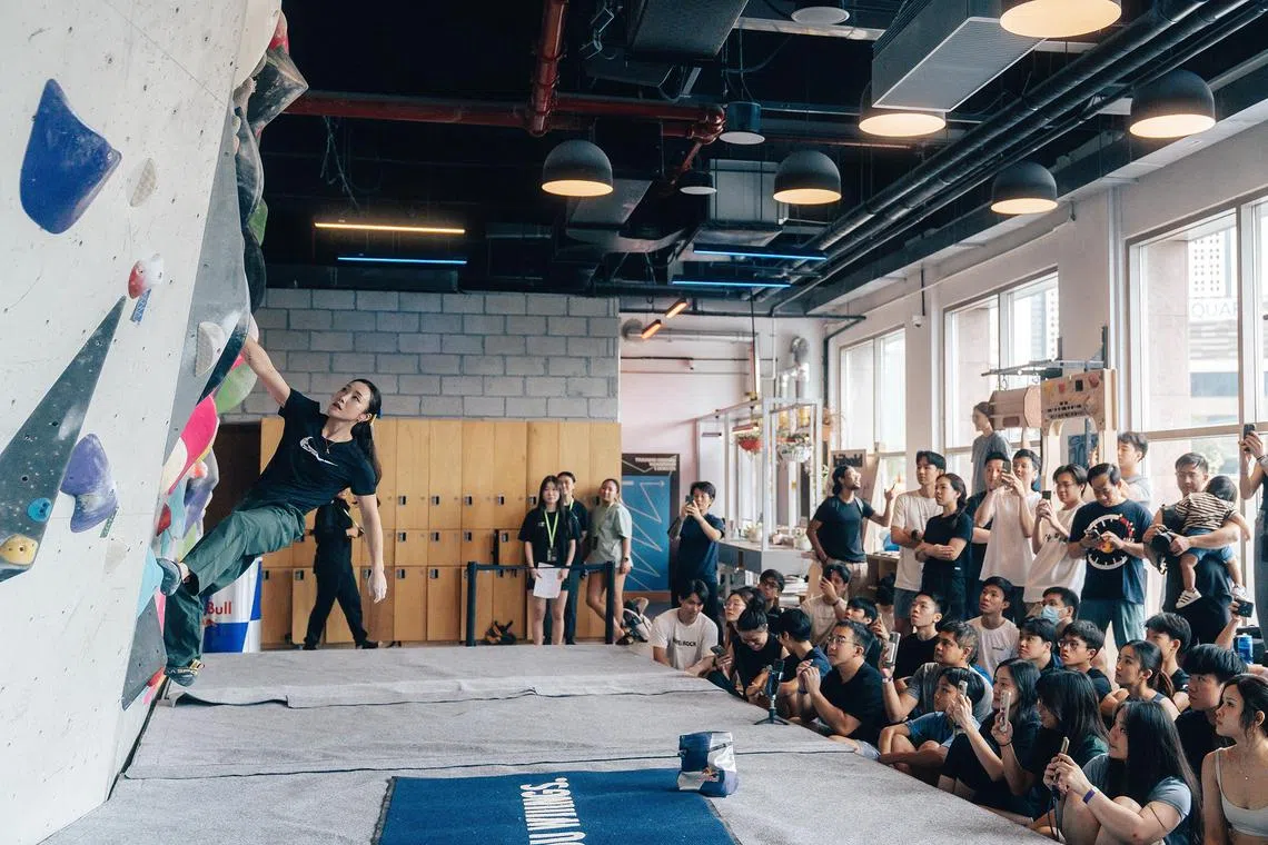 dgclimb01 - More than 30 local climbers watch closely as South Korean climber Jain Kim does a showcase climb at Project Send, a bouldering gym at the Esplanade

Credit: Red Bull