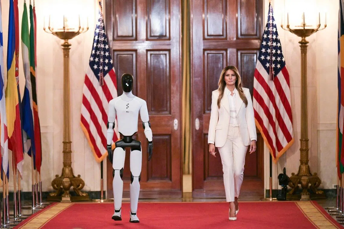 US First Lady Melania Trump walking with a humanoid robot as she arrives for the Fostering the Future Together Global Coalition Summit in the East Room of the White House in Washington, DC, U.S on March 25, 2026. 