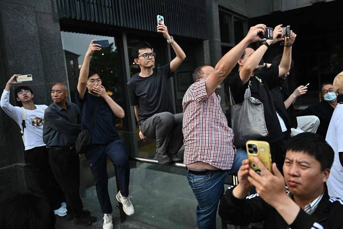 People gather to watch US President Donald Trump's motorcade in Beijing on May 14.