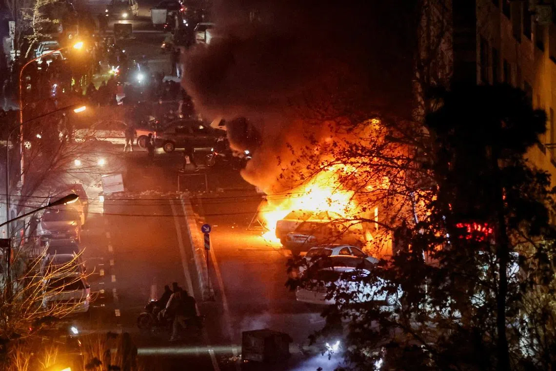 Cars burn in a street during a protest over the collapse of the currency's value, in Tehran, Iran, January 8, 2026. Stringer/WANA (West Asia News Agency) via REUTERS