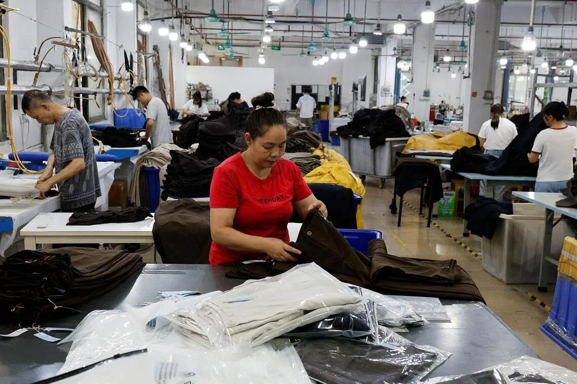 Employees work on a production line at a garment factory in Panyu District, Guangzhou, Guangdong province, China, July 27, 2026. REUTERS/Go Nakamura