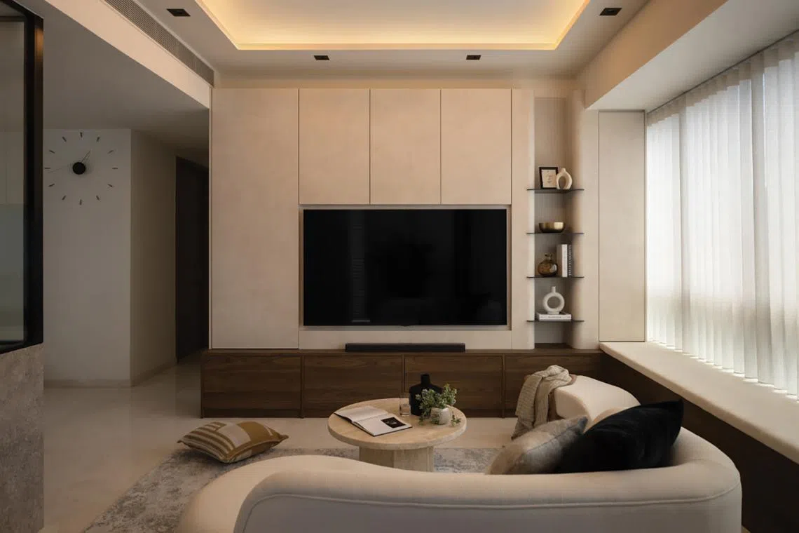 This neutral-toned living room sits within the larger unit of a dual-key apartment owned by a couple who work in the medical field.