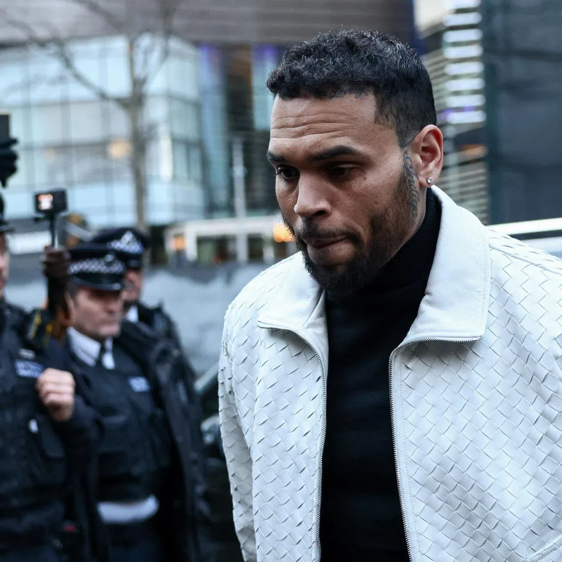 U.S. singer Chris Brown, who has been charged with inflicting grievous bodily harm in what prosecutors said was an \"unprovoked attack\" on a music producer at the Tape nightclub in central London in 2023, walks outside the Southwark Crown Court in London, Britain, January 28, 2026. REUTERS/Jack Taylor