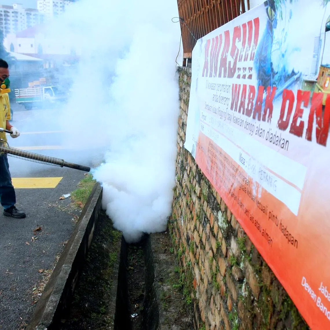 A worker fogging a mosquito breeding area in Kuala Lumpur.