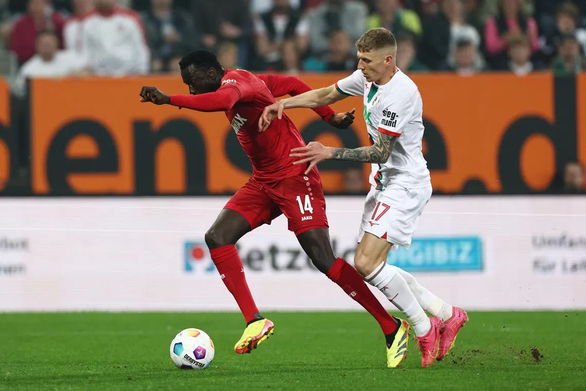Stuttgart's Silas Katompa Mvumpa holding off Augsburg's Kristijan Jakic in their Bundesliga match on May 10, 2024.