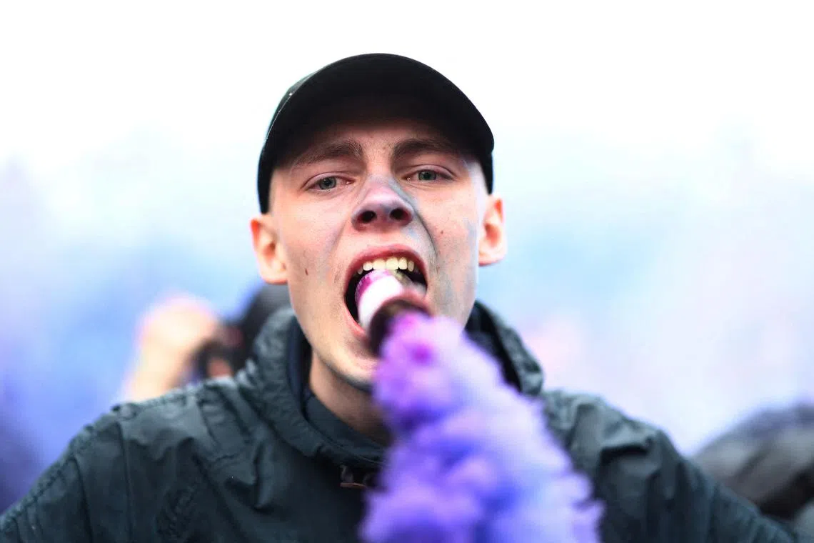 A fan with a flare outside the stadium before the match during the Premier League match between Aston Villa and Liverpool held at Villa Park, Birmingham, Britain, on May 13, 2024.