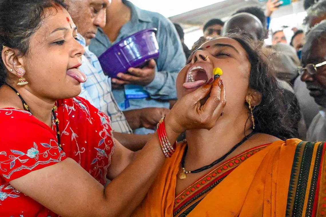 A patient swallows live murrel fish with herbs to cure asthma as administered by the Bathini Goud family, at the exhibition grounds in Hyderabad, Pakistan, on June 9.