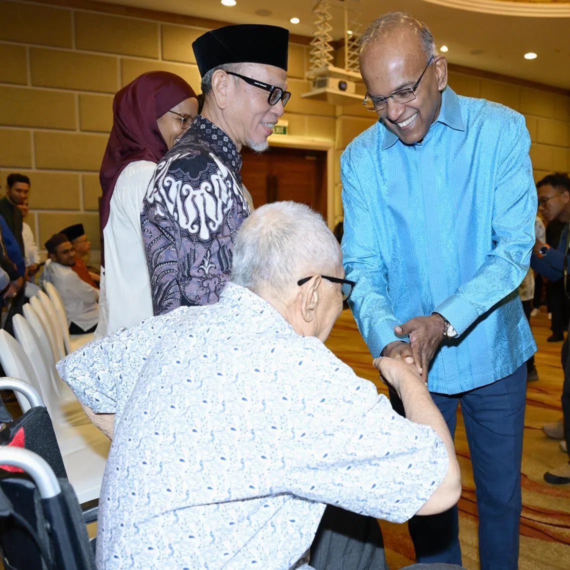 Minister for Home Affairs K Shanmugam greeting attendees at the Religious Rehabilitation Group's (RRG) 21st annual retreat on June 2, including religious teacher and volunteer counselor Yusof Ali (seated).