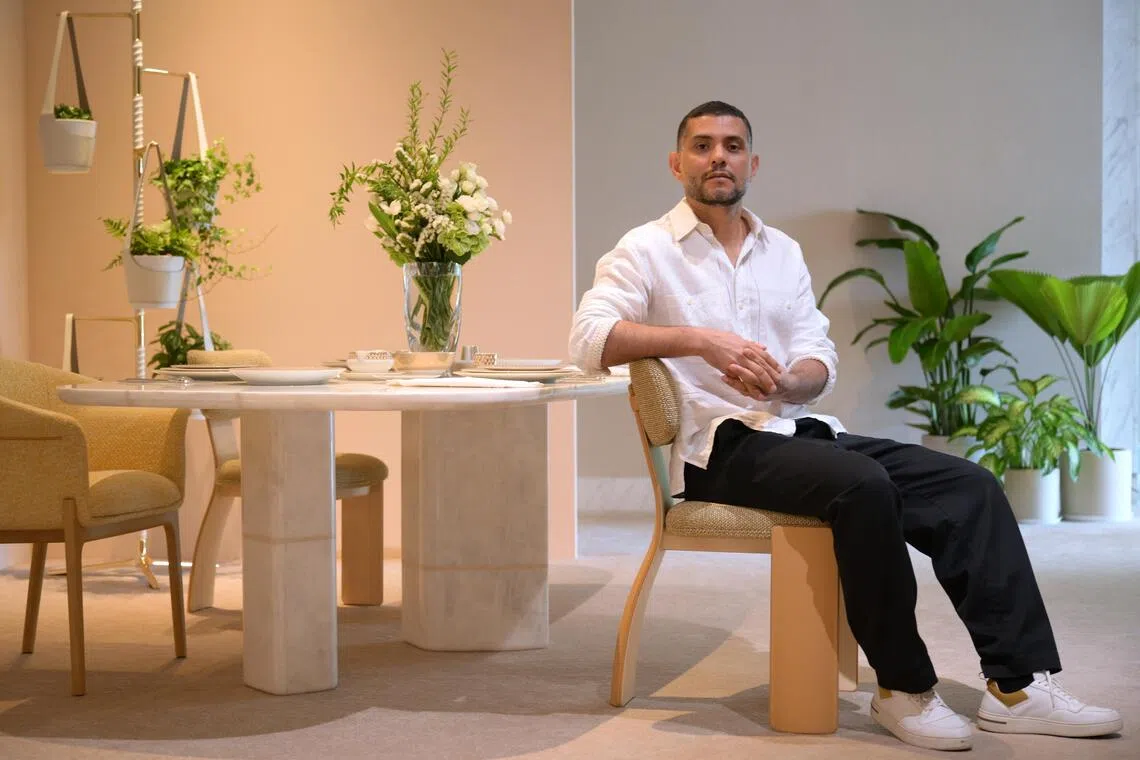 Louis Vuitton's Home Collections designer Cristian Mohaded at the Louis Vuitton Savoir Rever event at Mett Singapore hotel in Fort Canning.. He is pictured with two of his designs - the Pegaso Chair and the Atlas Table.