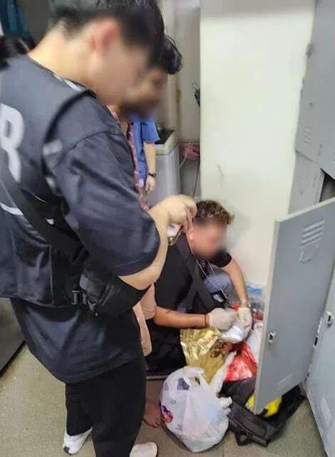 CNB officers conducting a search of a locker belonging to a suspected drug offender at a foreign worker dormitory in the vicinity of Jurong on July 16.