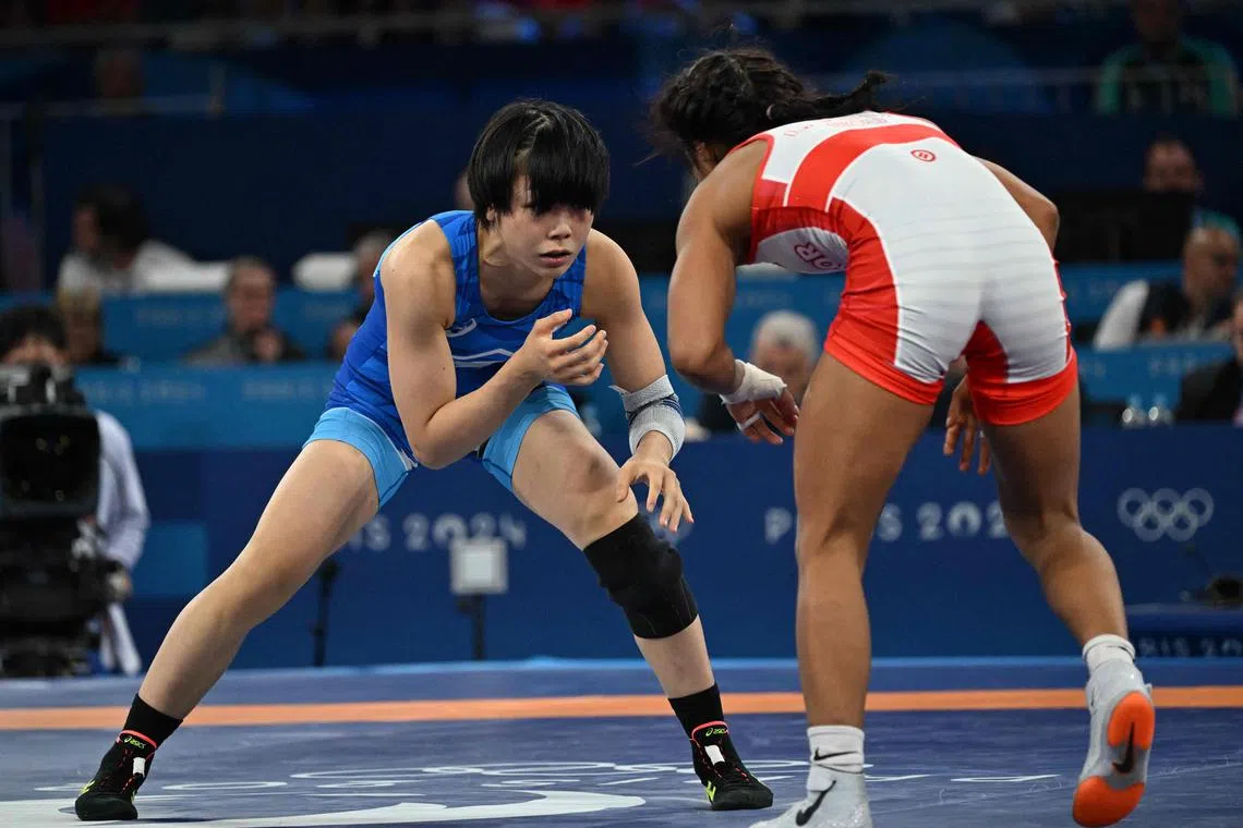 Japan's Akari Fujinami wrestling Ecuador's Lucia Yamileth Yepez Guzman in their women's freestyle 53kg final at the Champ-de-Mars Arena during the Paris Olympic Games on Aug 8, 2024.