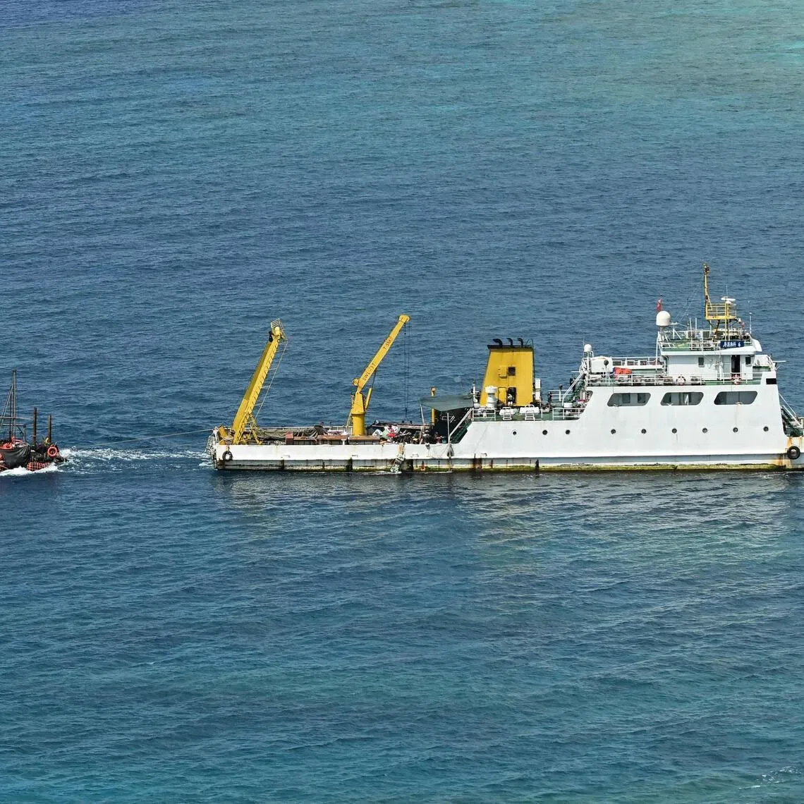 A ship identified by the Philippine Coast Guard as a Chinese research vessel is seen towing a floating structure.