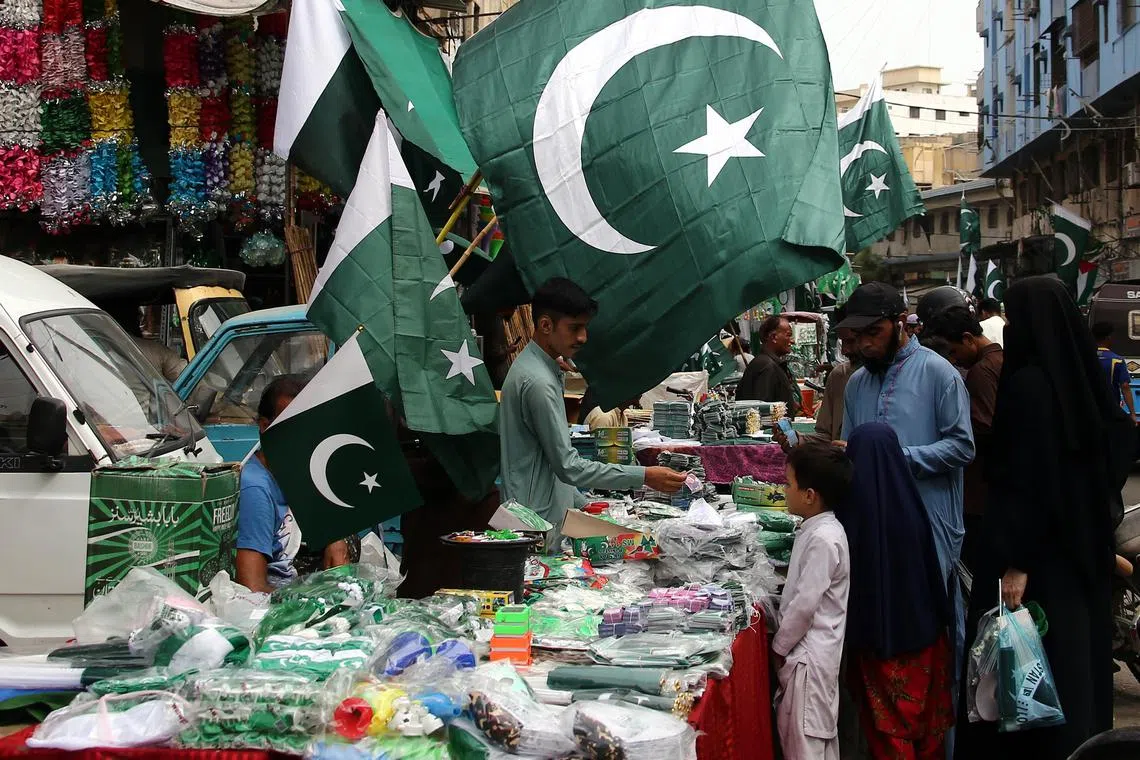 People shopping for decorative items in the colours of the Pakistan national flag, ahead of Independence Day celebrations, in Karachi, on Aug 1.