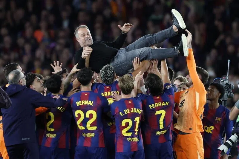 FC Barcelona's players and their head coach Hansi Flick (centre) celebrate the 2025/2026 Spanish La Liga Championship after winning the match against Real Madrid on May 10.
