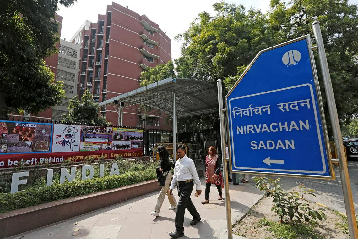 FILE PHOTO: People walk past the Election Commission of India office building in New Delhi, India March 11, 2019. REUTERS/Adnan Abidi//File Photo