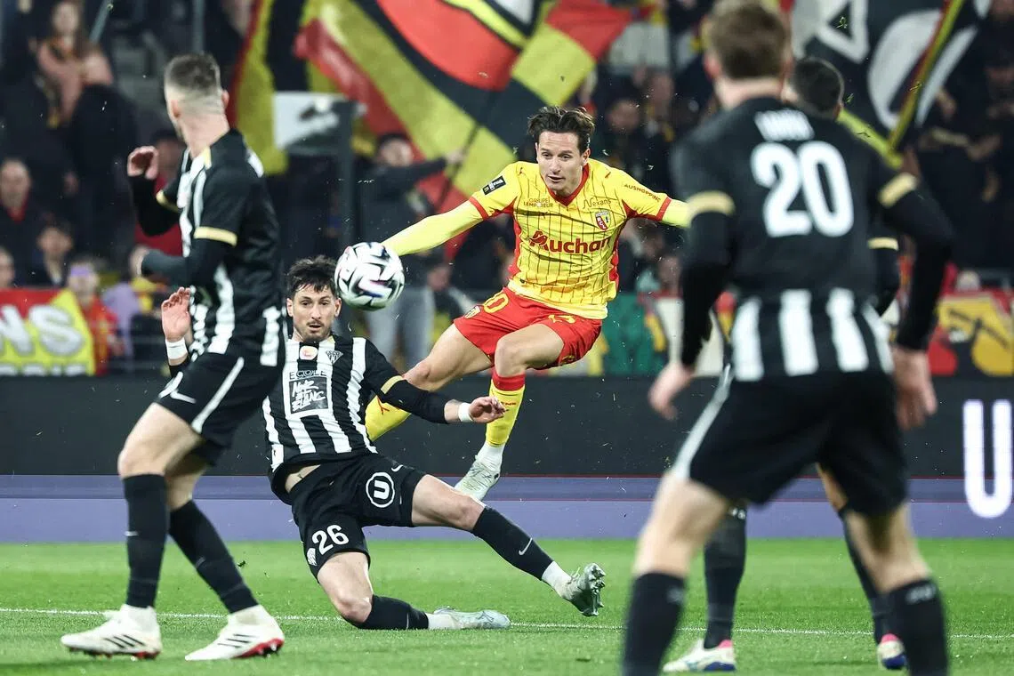Lens' French forward Florian Thauvin is tackled by Angers' French defender Florent Hanin in their French Ligue 1 football match at the Stade Bollaert-Delelis in Lens, northern France, on March 20, 2026.