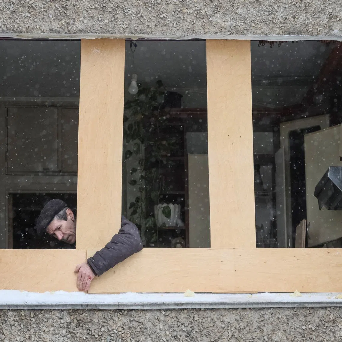 FILE PHOTO: A man installs an OSB board in place of a broken window at his apartment building damaged during a Russian overnight drone strike, amid Russia's attack on Ukraine, in Kyiv, Ukraine February 5, 2026. REUTERS/Gleb Garanich/File Photo