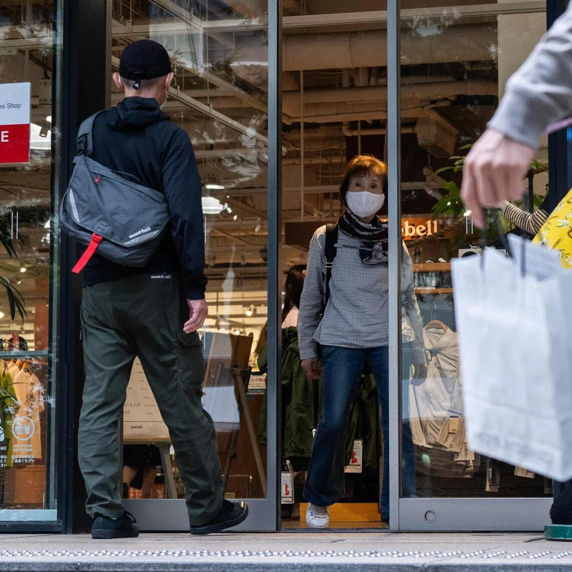 People enter an outdoor store with a tax free for tourists sign displayed on its facade in Tokyo on June 23.