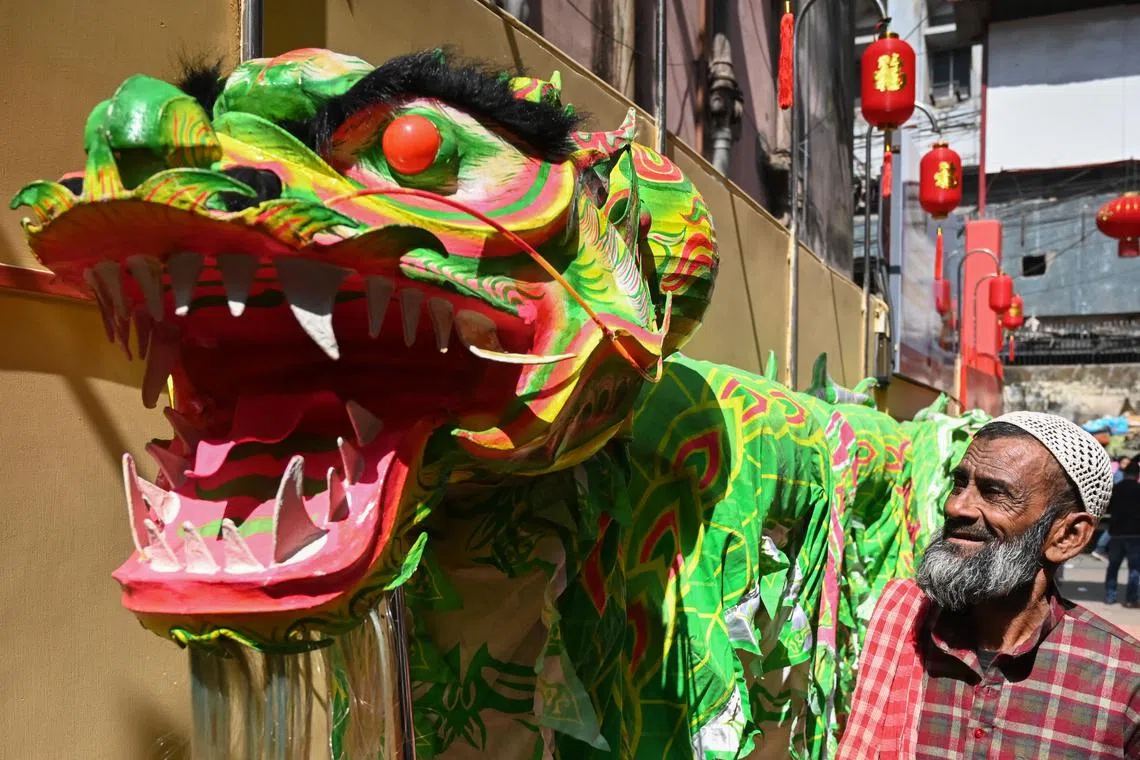 A man looking on as members of the Chinese community take part in a traditional dragon dance in Kolkata on Feb 10, 2024, on the first day of the Lunar New Year of the Dragon.