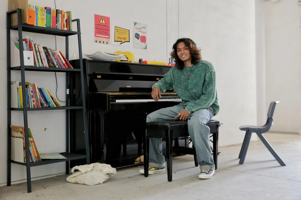 wwpiano30 - Student Adam Syah, 21, poses for a photograph in front of a community piano at the void deck of Block 107 Yishun Ring Road, Dec 29, 2022. Mr Adam, who works part time as a GrabFood delivery rider, shot to fame after videos of him playing the piano went viral on Tiktok. 

Byline: Wallace Woon