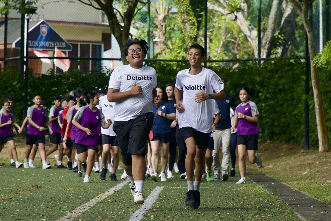 NorthLight students Muhamad Shazali Juma’at (front, left) and Mohamed Ali Khan Borhan (front, right), both 15, leading students and staff from the school in a run at the school on Aug 14, 2025. Both Year 3 students are taking part in Deloitte’s 6000 for 60 fundraising run.