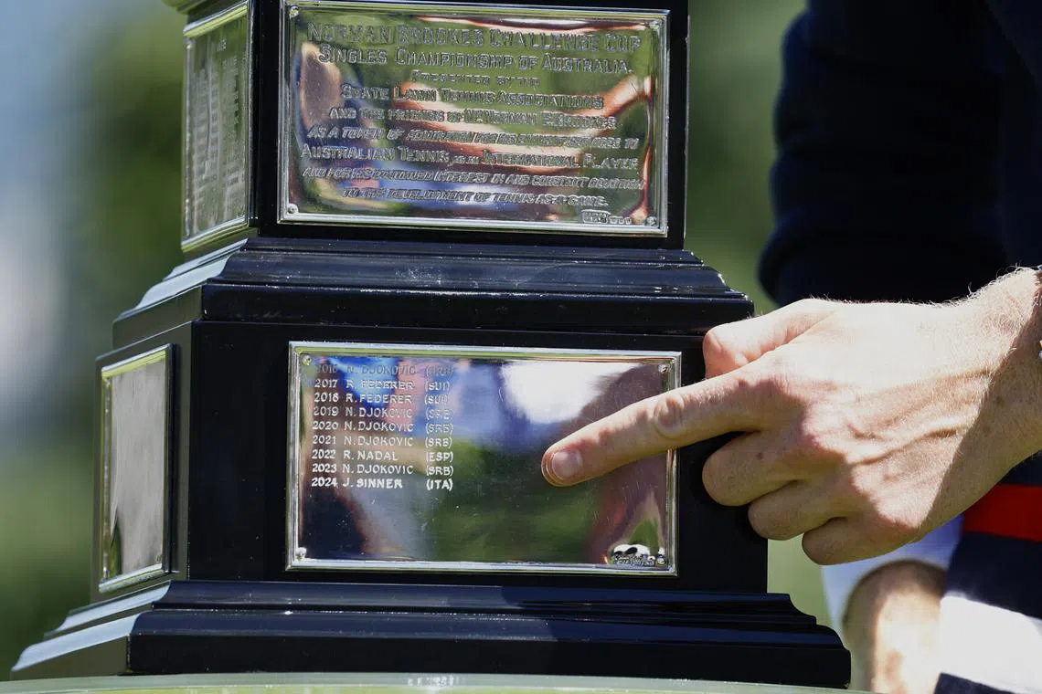 Tennis - Australian Open - Men's Singles Winner Photo Shoot - Royal Botanic Gardens Victoria, Melbourne, Australia - January 29, 2024 Italy's Jannik Sinner points to his name on the Australian Open trophy winners' plaque REUTERS/Issei Kato