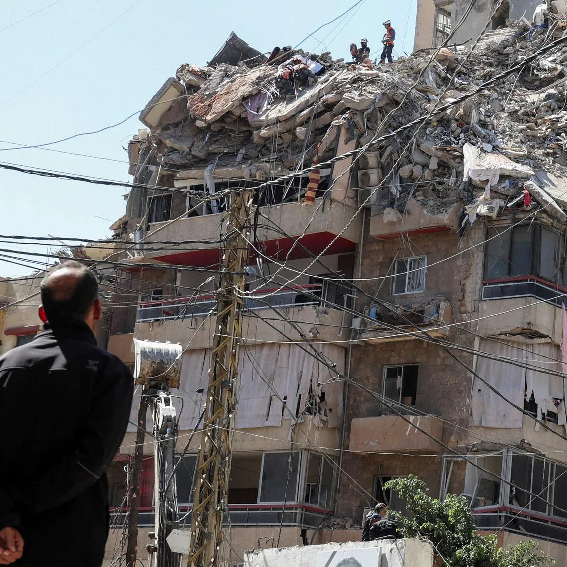 A man watches as rescuers work at the site of an Israeli strike that took place yesterday, in the southern suburbs of Beirut, Lebanon, May 7, 2026. REUTERS/Mohamad Azakir