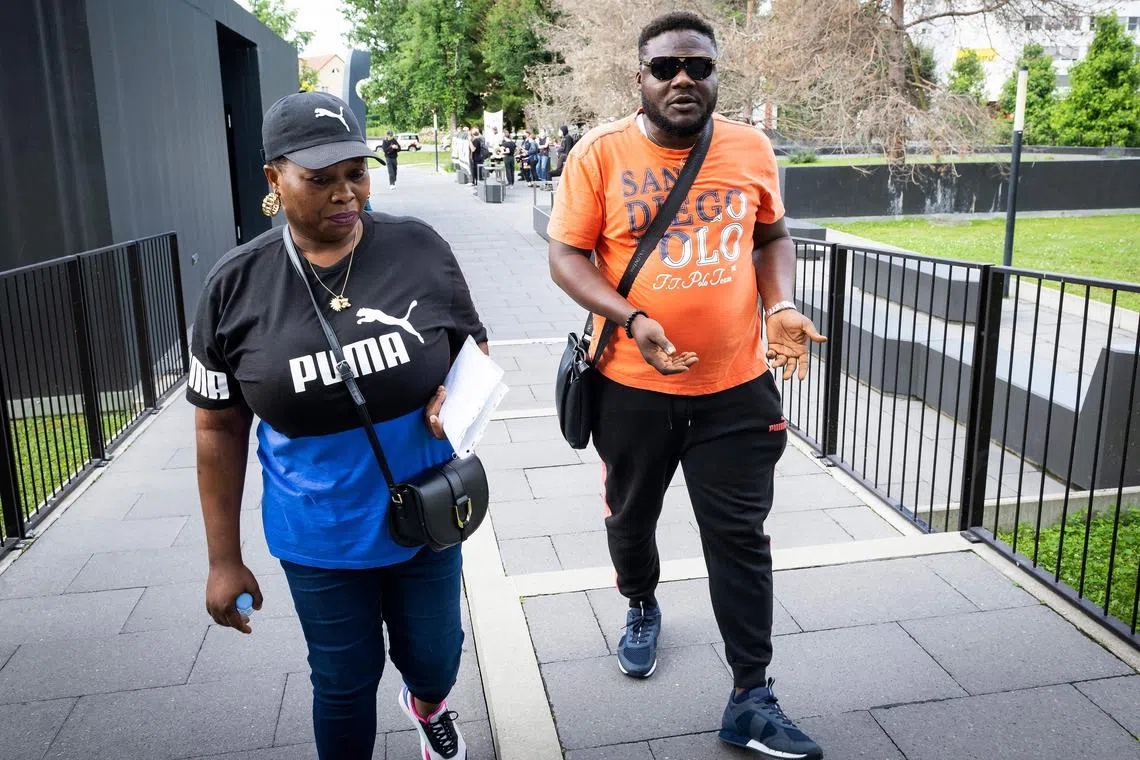 Bridget Efe (left), the widow of Mike Ben Peter, arrives with Ben Peter's brother at the criminal court for the appeal trial.