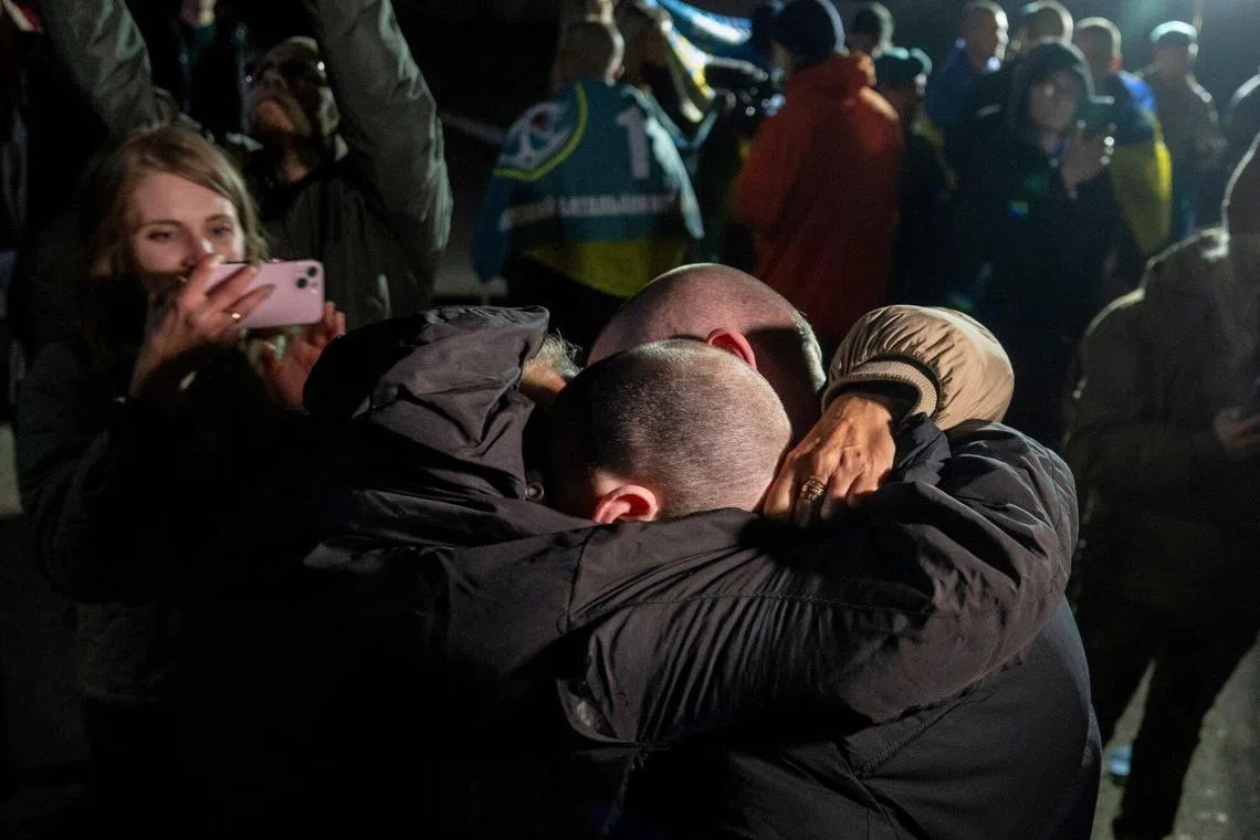Relatives and military personnel welcome Ukrainian prisoners of war (POW) following a prisoner swop with Russia at an undisclosed location in Ukraine, on  Oct. 18.