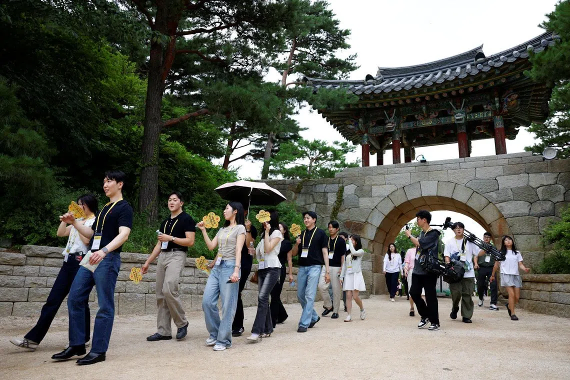 Participants walk through the grounds of Naksansa temple during a Buddhist temple matchmaking programme.