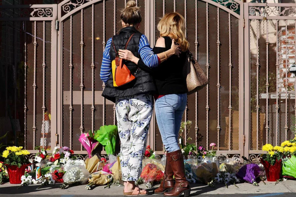 People embrace at a makeshift memorial outside the scene of a deadly mass shooting at a ballroom dance studio on Jan 23, 2023, in Monterey Park, California. 