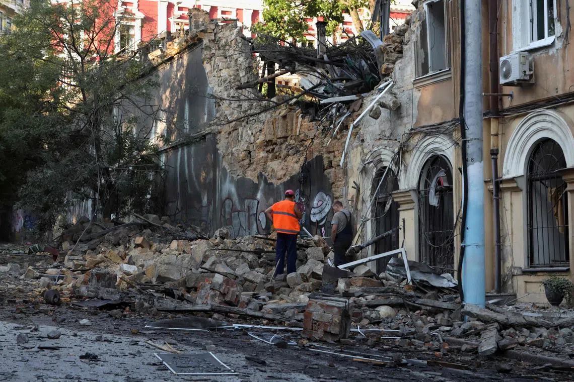 Men stand among the rubble of a building  hit by a missile strike, amid Russia's invasion, in Odesa.
