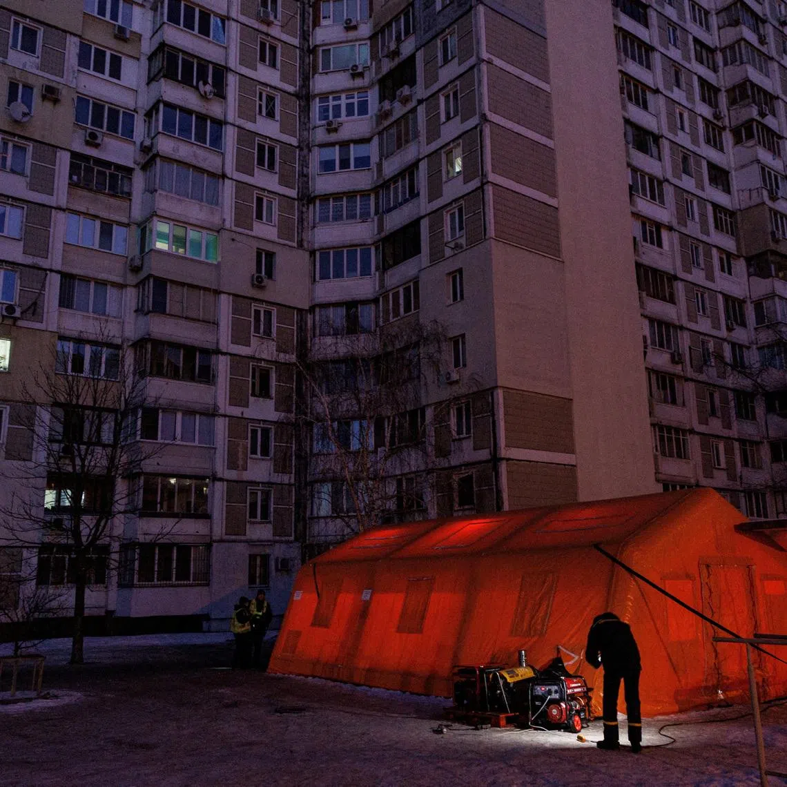 A State Emergency Service employee checks a generator next to a tent of a government-run humanitarian aid point, where residents can warm up, charge their devices, get hot drinks and psychological support, installed next to apartment buildings during a power blackout after critical civil infrastructure was hit by overnight Russian missile and drone strikes, amid Russia's attack on Ukraine, in Kyiv, Ukraine, January 20, 2026. REUTERS/Valentyn Ogirenko
