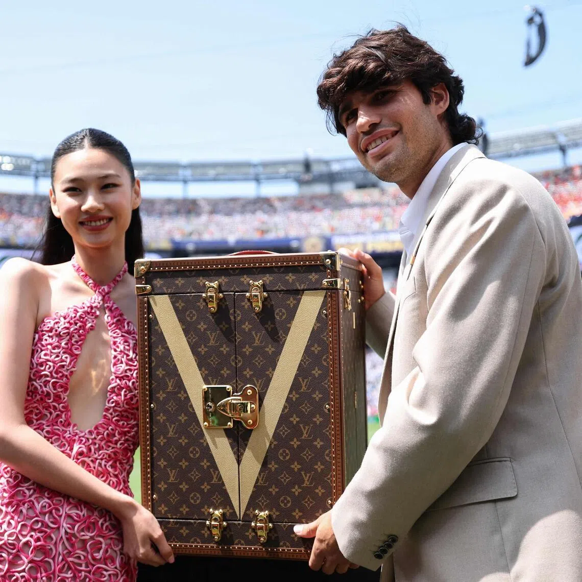 South Korean actress Hoyeon (left) was joined by Spanish tennis star Carlos Alcaraz as the pair carried the World Cup trophy in a specially designed Louis Vuitton case.