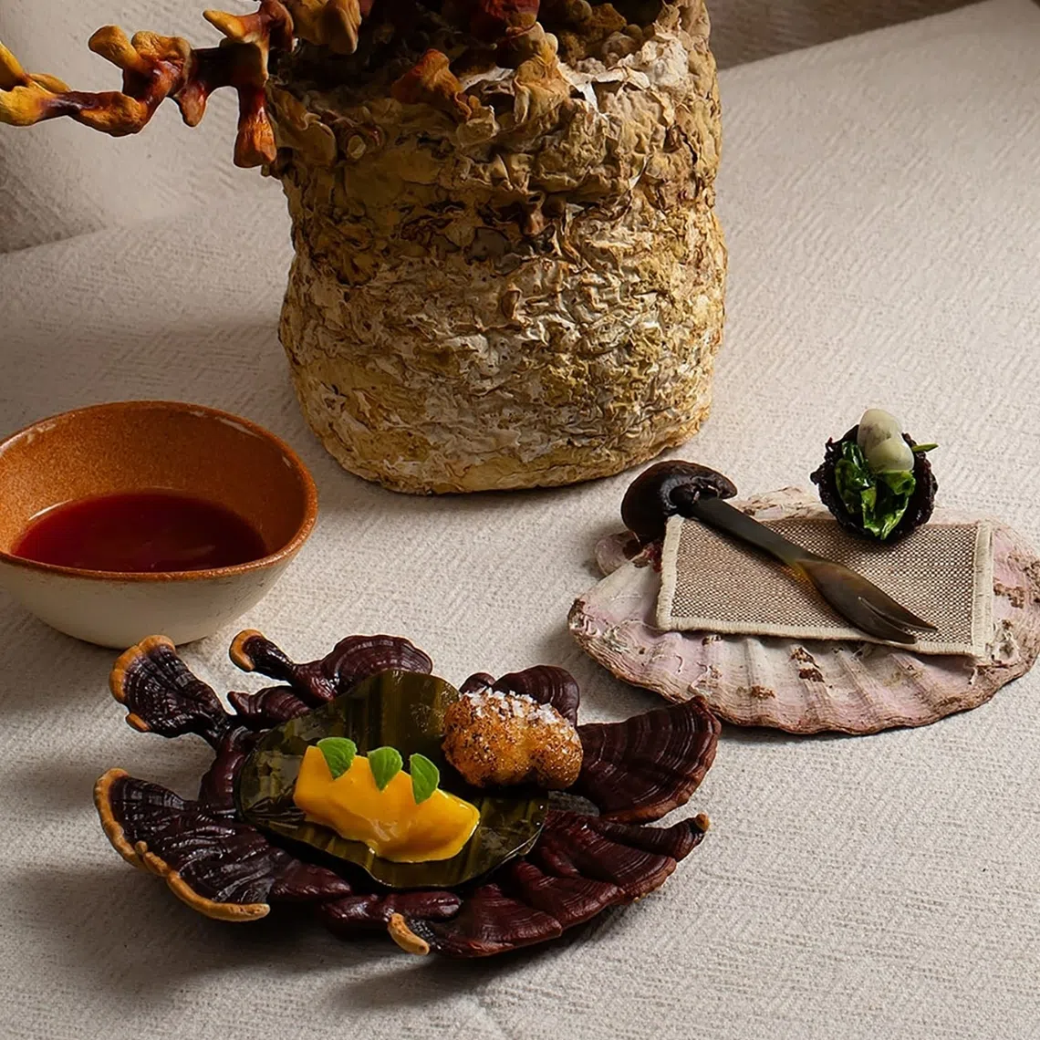 Ditali pasta (left).  Scallop paired with a mushroom selected by the guest, plum and pomegranate broth, and dehydrated plum filled with golden oyster mushroom, lovage, and parsley.