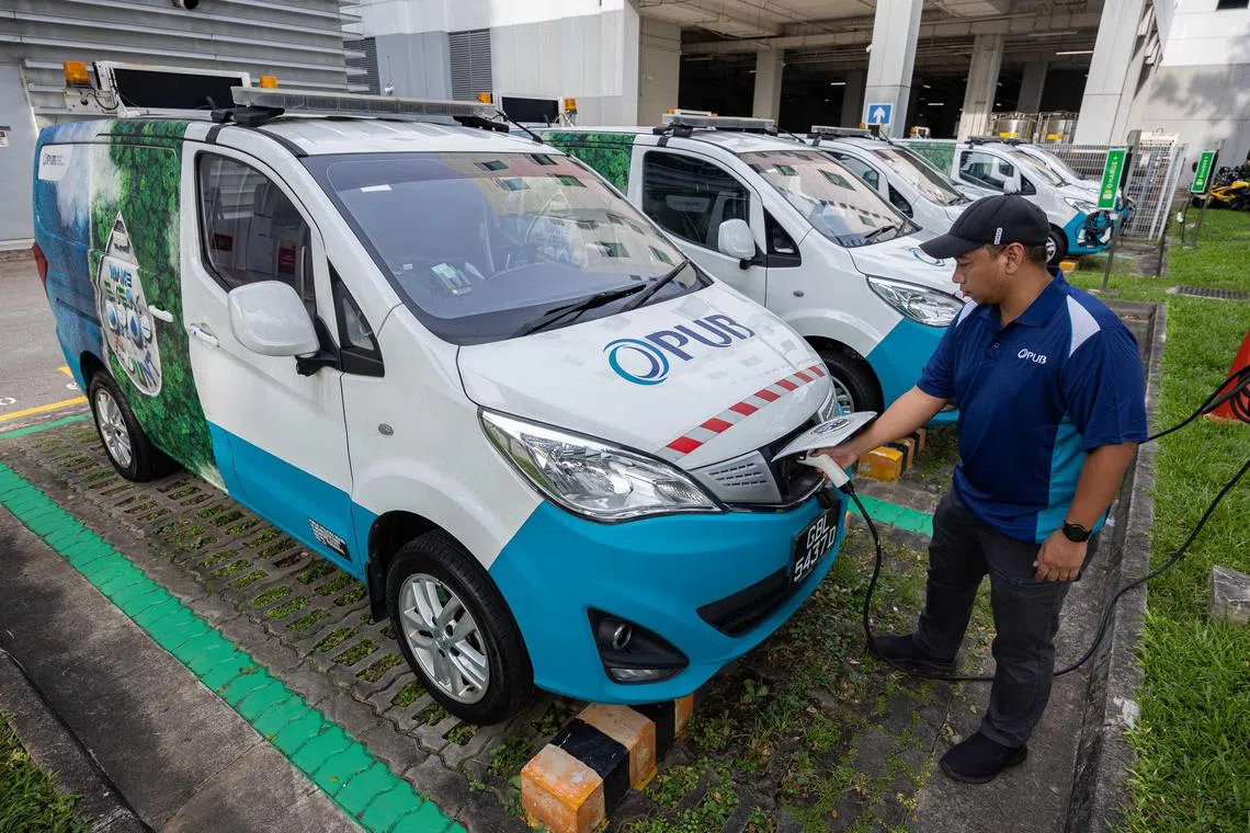 ST20240716_202488000278/ntev/Brian Teo/Lee Nian Tjoe/A PUB officer charging the electric vans parked at PUB Water Hub on July 17, 2024. PUB has ordered 47 electric vans and trucks to replace its diesel engine vehicles. ST PHOTO: BRIAN TEO.