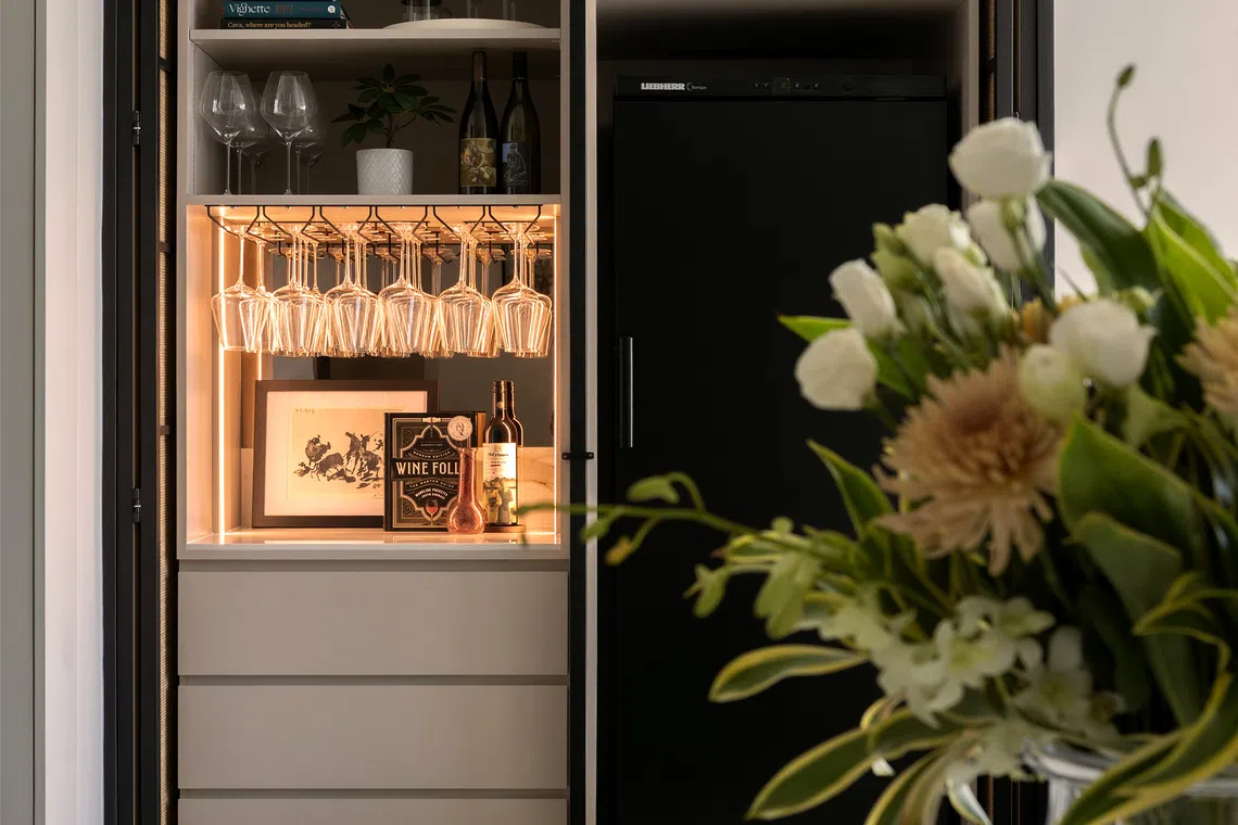 The arched rattan cabinet creates a striking focal point for the bar.