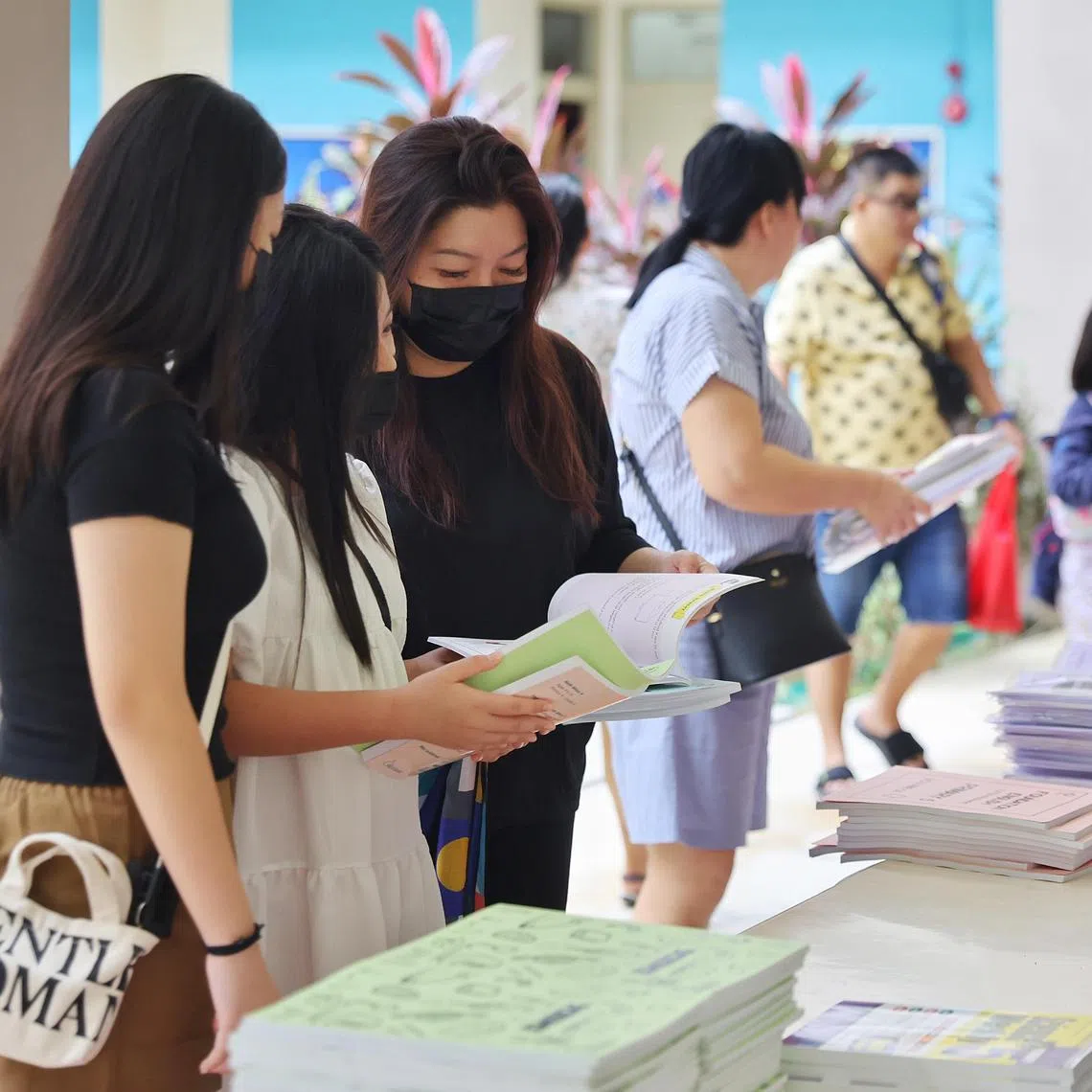ST20231203_202337926945/elschool03/Esther Loi/Jason Quah

Chinese Development Assistance Council (CDAC) beneficiary family Madam Pauline Fong (R), 45, part-time receptionist and part-time administrative executive and her daughters Chen Yi Yuan (in white), 12, student 
Chen Yi Xin, 13, student, browsing assessment books at the CDAC Ready For School event at Nanyang Junior College on Dec 3, 2023.