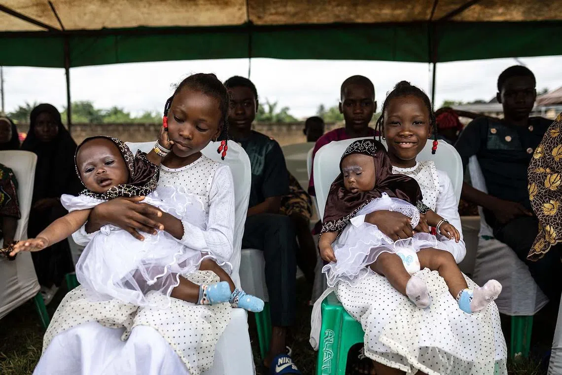 TOPSHOT - Twins look on as they attend the Igboora World Twins Festival 2024, in Igbo-Ora on October 12, 2024. Nigeria’s self-proclaimed ‘twins capital of the world’ Igbo-Ora holds its annual festival to celebrate the town’s unusually high incidence of multiple births. (Photo by OLYMPIA DE MAISMONT / AFP)