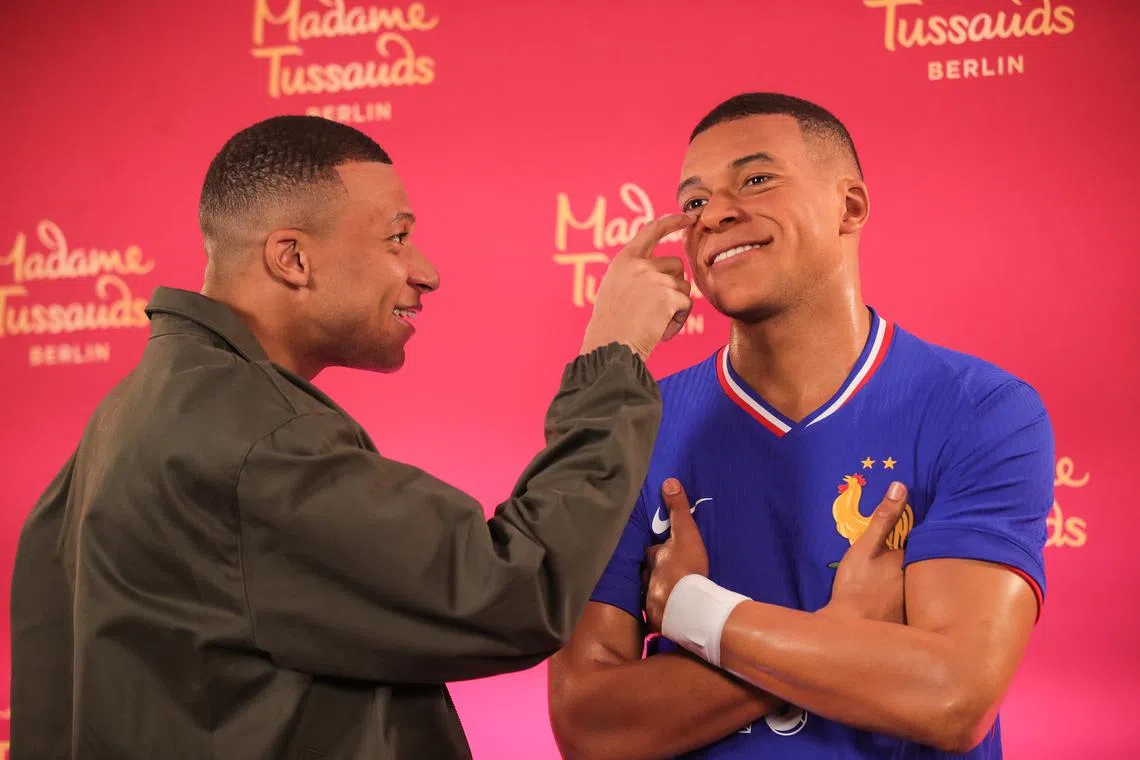 French soccer player Kylian Mbappe (left) posing with his Madame Tussauds wax figure during the unveiling in Paris, France, on May 16, 2024. 
