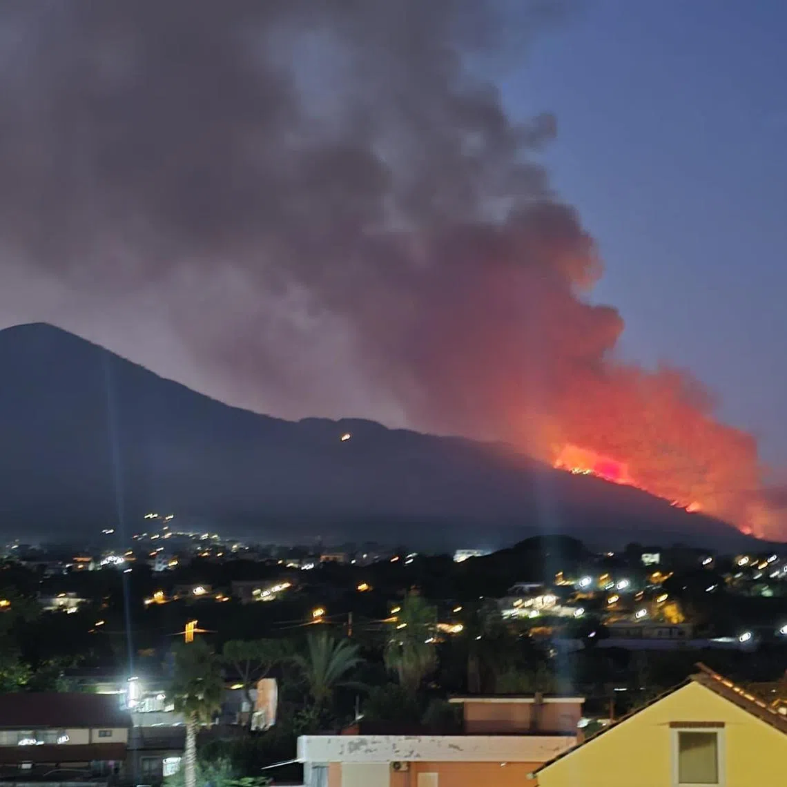 epa12290561 A large fire is raging in a green area on the slopes of Mount Vesuvius near Naples, Italy, 08 August 2025. A tall column of smoke has risen into the sky and is visible from Naples. Firefighters are on site to contain the blaze. EPA/CESARE ABBATE