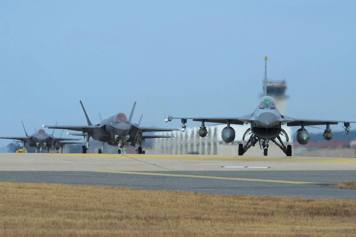 This handout photo taken on Dec 3, 2017, shows US Air Force F-16 Fighting Falcon (R) and F-35A Lightning II fighter jets taxiing at South Korea's Kunsan Air Base.