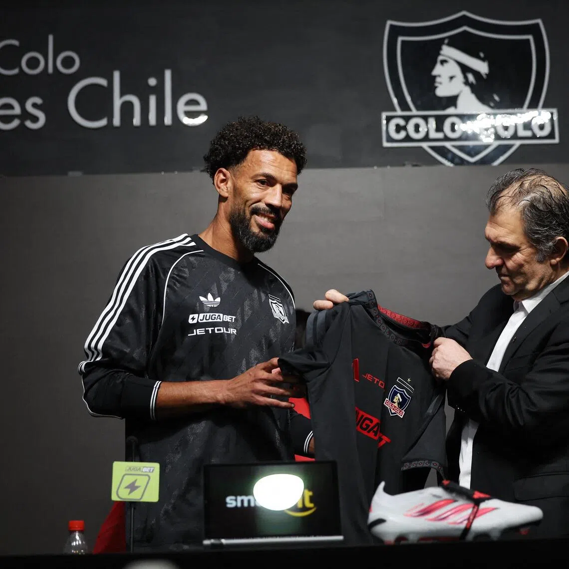 Colo Colo president Anibal Mosa presenting the club’s new signing Vozinha with his goalkeeper’s jersey at a press conference at Estadio Monumental in Santiago, Chile on Aug 4.