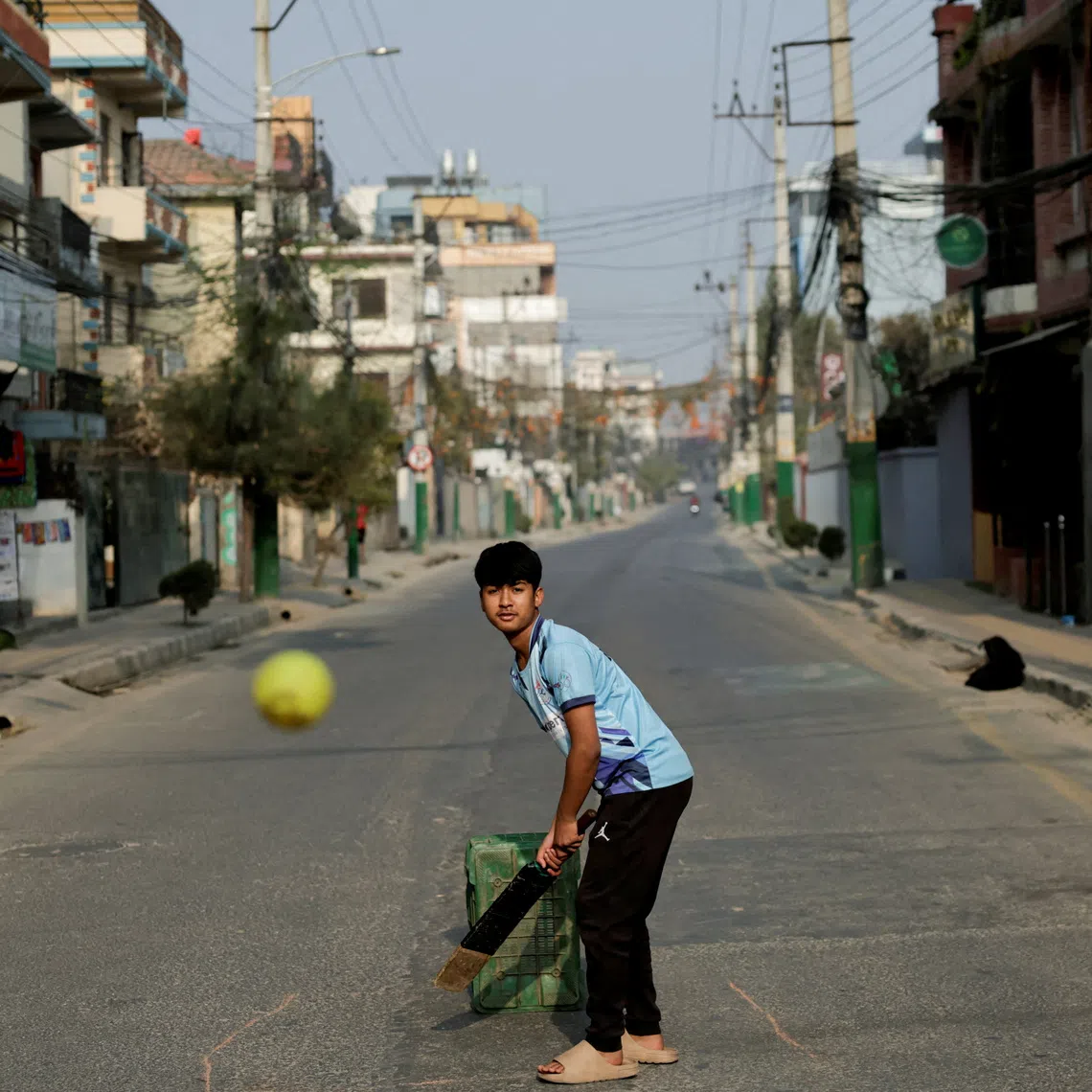 FILE PHOTO: A boy plays cricket on an empty road during the general election in Lalitpur, Nepal, March 5, 2026. REUTERS/Navesh Chitrakar/File Photo