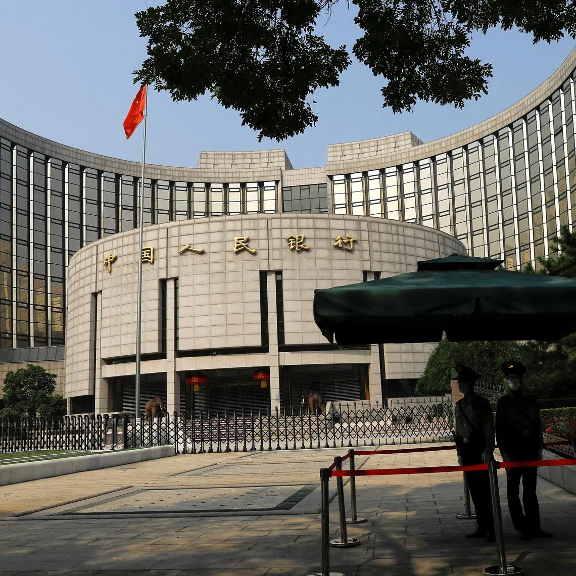 Paramilitary police officers stand guard in front of the headquarters of the People's Bank of China, the central bank (PBOC), in Beijing, China September 30, 2022. REUTERS/Tingshu Wang/File Photo