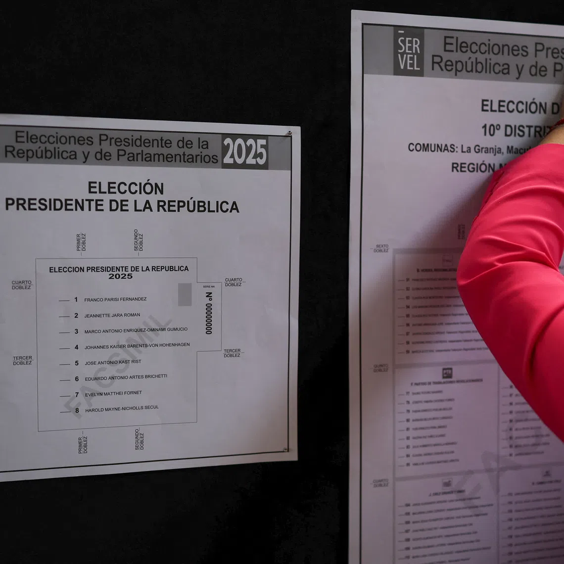 A worker posts election information at a polling station during an activity organized by SERVEL, Chile's Electoral Service, ahead of the November 16 presidential election, in Santiago, Chile, November 14, 2025. REUTERS/Pablo Sanhueza