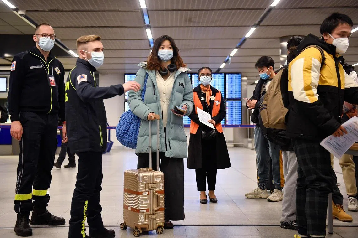 Passengers leaving a flight from China wait in a line for their Covid-19 vaccination documents to be checked in Paris, France.