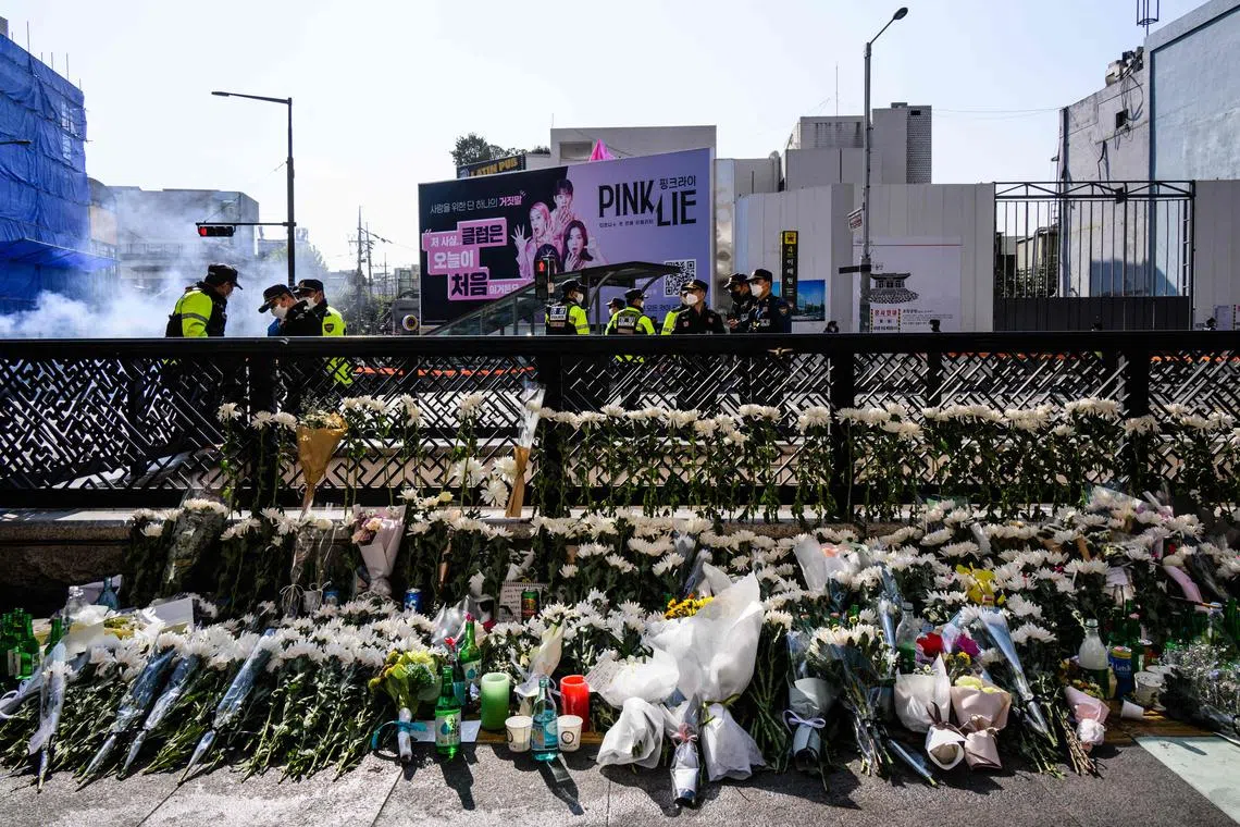 Floral tributes are seen at a makeshift memorial outside a subway station in the district of Itaewon in Seoul on Oct 31, 2022.