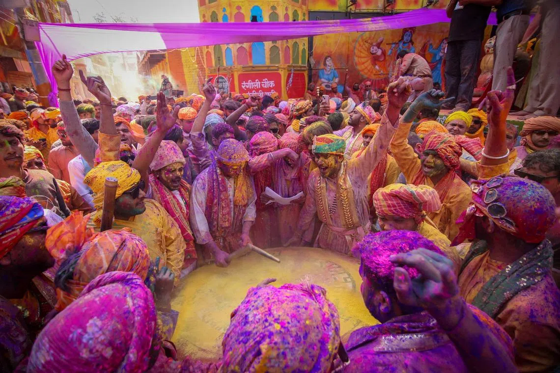 Men daubed in colours throwing coloured powder at each other during "Lathmar Holi" celebrations at Barsana, Uttar Pradesh, India, on Feb 25, 2026. 